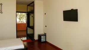Una habitación con una cama y un televisor en una pared. en Zagwe Hotel, en Lalibela