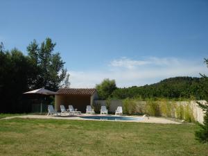 um quintal com piscina e cadeiras e uma casa em house in the countryside in the luberon with beautiful view and private swimming-pool close to bonnieux in Provence - 8 personnes em Bonnieux