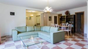 Villa Girassol في فيلامورا: غرفة معيشة مع أريكة زرقاء وطاولة