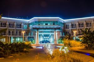 a building with a fountain in front of it at night at Pefaco Hotel Maya Maya in Brazzaville