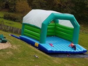 a person sitting on a inflatable play structure in the grass at De Hollemeersch Hotel in Dranouter