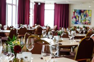 a dining room with tables and chairs with wine glasses at Hotell Nissastigen in Gislaved