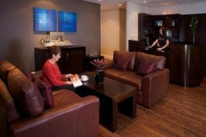 a woman sitting on a couch in a living room at The Bannatyne Spa Hotel in Hastings