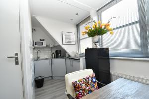 a kitchen and dining room with a table and a vase of flowers at Vrijvakantiehuis Roosjesweg 1a in Domburg