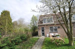 una casa de ladrillo con una mesa y sillas en el patio en Roosjesweg 1a en Domburg