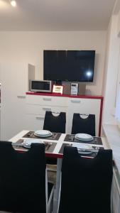 a dining room table with chairs and a tv at Apartment D&B in Ljubljana