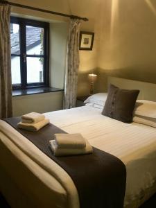 a bedroom with a bed with two towels on it at The Cavendish Arms in Cartmel