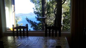a table with two chairs and a view of a window at Aucapillan in San Carlos de Bariloche
