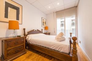 マドリードにあるFor You Rentals Velazquez apartment VEL55のベッドルーム1室(ドレッサー付きのベッド1台、窓付)