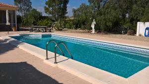 een zwembad met blauw water in een tuin bij Casa Gregory in Turre