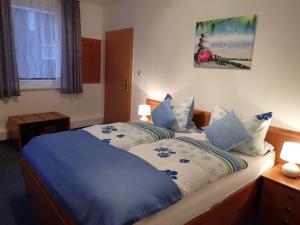 a bedroom with a large bed with blue sheets and pillows at Gästehaus Andrea in Hahnenklee-Bockswiese