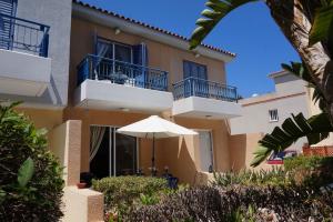 an apartment building with an umbrella in front of it at Aurora Townhouse - Complimentary Paphos Airport Transport in Paphos City