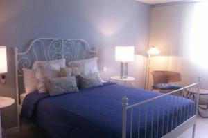 ein Schlafzimmer mit einem blauen Bett mit Kissen in der Unterkunft Primera linea de Playa de las Burras in San Agustín