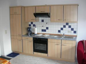 a kitchen with wooden cabinets and a sink at Ferienwohnung Am Zechenhaus in Bodenmais