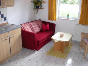 ein Wohnzimmer mit einem roten Sofa und einem Tisch in der Unterkunft Ferienwohnung Am Zechenhaus in Bodenmais