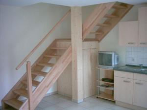eine Holztreppe in einer Küche mit Mikrowelle in der Unterkunft Ferienwohnung Am Zechenhaus in Bodenmais