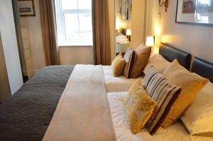 a bedroom with two beds with pillows and a window at The Bakehouse B&B in Seahouses