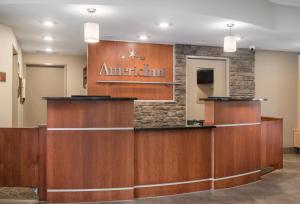 a lobby with a americanan sign on the wall at AmericInn by Wyndham Winona in Winona