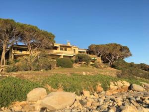 una casa grande en la cima de una colina con rocas en Sardinia Mon Amour, en Geremèas