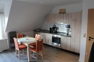 a kitchen with a table and chairs in a room at Ferienwohnungen Hensel in Minsen