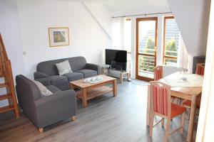 ein Wohnzimmer mit einem Sofa und einem Tisch in der Unterkunft Ferienwohnungen Hensel in Minsen