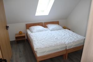 a bedroom with a bed with white sheets and a window at Ferienwohnungen Hensel in Minsen