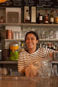 a woman sitting at a counter in a bar at Hôtel Restaurant Gédéon in Carnon-Plage