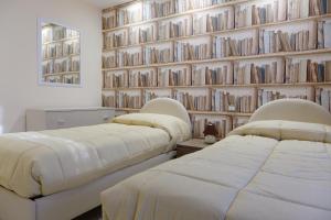 ヴィーコ・エクエンセにあるCasa Miclaの本の壁がある部屋のベッド2台