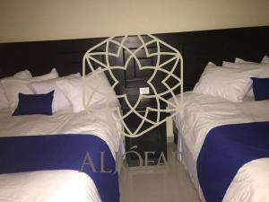 Hotel Aljófar في Montemorelos: سريرين في غرفة فندق مع سريرين sidx sidx