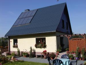 een huis met een zonnedak met een tafel en stoelen bij Ferienwohnung Petzold in Kurort Altenberg