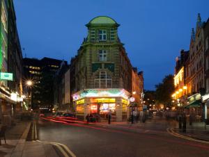 a building with a clock tower on a city street at The Z Hotel Soho in London