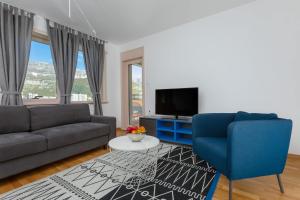 ein Wohnzimmer mit einem Sofa und einem TV in der Unterkunft Apartments Krug in Budva