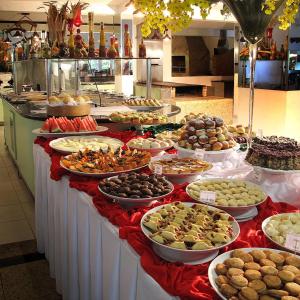 a buffet table filled with lots of different types of food at Resort Monte das Oliveiras in Joanópolis