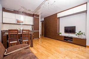 a kitchen and living room with a table and a television at Apartament Polar in Poznań