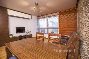 a dining room with a table and chairs and a television at Apartament Polar in Poznań