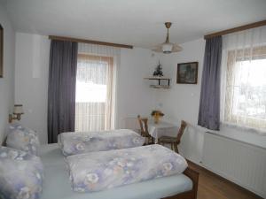 1 dormitorio con 2 camas, mesa y ventanas en Apartments Jäger en Trins