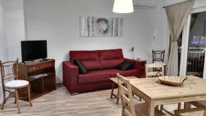 sala de estar con sofá rojo y mesa en Apartamentos Rivera, en Alicante