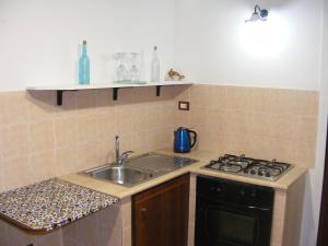 a kitchen with a sink and a stove at Alice's Apartment in Castellammare del Golfo