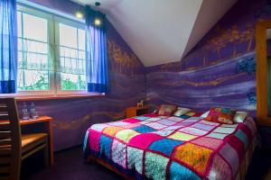 a bedroom with a bed with a colorful quilt at TOPOLEJ - Etno Chata in Ustroń