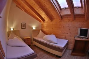 um pequeno quarto com 2 camas e uma televisão em Dependance Central em Ischgl