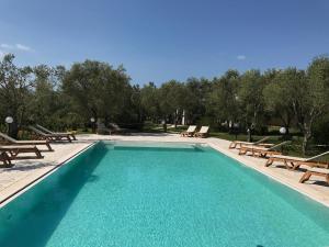 a swimming pool with picnic tables and benches at Agriturismo Terra Rossa in Otranto
