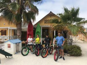 um grupo de pessoas de pé com suas bicicletas em frente a um edifício em Condominio Bahia Inglesa em Bahia Inglesa