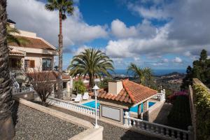 a house with a swimming pool and palm trees at Teresita High Views with private pool in Santa Brígida