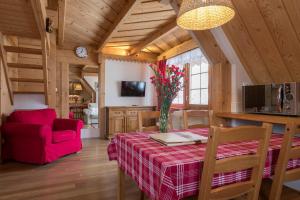 a dining room with a table and a red chair at Bambi Cottage in Zakopane
