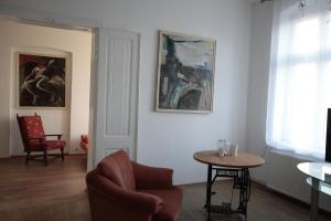 カリシュにあるPrzestronny Apartamentのリビングルーム(椅子、テーブル付)