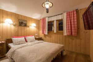 a bedroom with a bed and two windows at Bambi Cottage in Zakopane