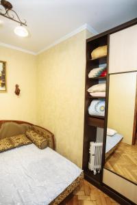a bedroom with a bed and a shelf with towels at Halytska in Lviv