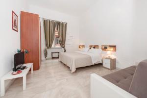 ローマにあるB&B Two Flowersのベッドとソファ付きのホテルルーム