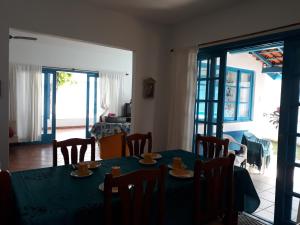 - une salle à manger avec une table, des chaises et une porte dans l'établissement Casa perto da praia, à Itanhaém