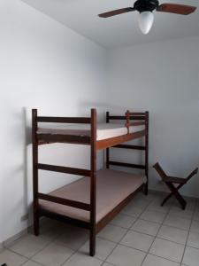 Cette chambre dispose d'un ventilateur de plafond et d'une étagère. dans l'établissement Casa perto da praia, à Itanhaém